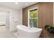 Bathroom with freestanding tub and wood accent wall at 2350 Via Venice, Punta Gorda, FL 33950