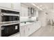 Modern kitchen with white cabinets, stainless steel appliances, and a teal backsplash at 2350 Via Venice, Punta Gorda, FL 33950