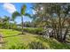 Beautiful backyard with a lush lawn, mature trees, and a charming bridge leading to serene waterfront at 2500 Jamaica St, Sarasota, FL 34231
