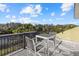 Outdoor balcony with table and two chairs offering scenic views of the surrounding landscape and blue skies at 2500 Jamaica St, Sarasota, FL 34231