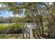 A private dock provides direct access to the water, shaded by mature trees and lush landscaping at 2500 Jamaica St, Sarasota, FL 34231