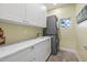 The laundry room has ample counter space, modern machines, sink, and stylish cabinetry at 2500 Jamaica St, Sarasota, FL 34231