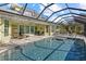 Stunning screened-in pool area showcasing lounge chairs, beautiful water views, and seamless indoor/outdoor living at 2500 Jamaica St, Sarasota, FL 34231