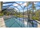 Gorgeous screened-in pool surrounded by lush greenery, offering a private oasis with views of the water at 2500 Jamaica St, Sarasota, FL 34231