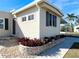 Side view of a tan single-wide manufactured home with landscaping at 3214 Pink Oak Ter, Sarasota, FL 34237