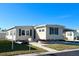Tan single-wide manufactured home with covered carport and landscaping at 3214 Pink Oak Ter, Sarasota, FL 34237