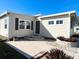 Side view of a tan single-wide manufactured home with landscaping at 3214 Pink Oak Ter, Sarasota, FL 34237