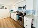 Updated kitchen with white cabinets and blue tile backsplash at 3214 Pink Oak Ter, Sarasota, FL 34237