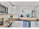 Modern kitchen with stainless steel appliances and white cabinets at 4500 Gulf Of Mexico Dr # 305, Longboat Key, FL 34228