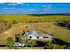 Aerial view of the barn and surrounding fields with lake in the distance at 4939 Myakka Valley Trl, Sarasota, FL 34241