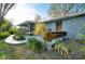 Backyard featuring a wooden deck, lush landscaping, and a view of the screened porch at 4939 Myakka Valley Trl, Sarasota, FL 34241