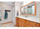 Bathroom with wood cabinets, white countertops, tile floors and a large mirror at 4939 Myakka Valley Trl, Sarasota, FL 34241