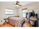 Comfortable bedroom featuring two windows, a ceiling fan and wood floors at 4939 Myakka Valley Trl, Sarasota, FL 34241