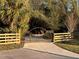 Community entrance gate with wood fencing, concrete drive and attractive design at 4939 Myakka Valley Trl, Sarasota, FL 34241