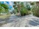 Long driveway leading to home and garage, surrounded by tropical trees at 4939 Myakka Valley Trl, Sarasota, FL 34241
