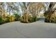 Concrete driveway leads to a ranch home surrounded by mature trees and lush landscaping at 4939 Myakka Valley Trl, Sarasota, FL 34241