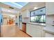 Bright kitchen featuring white cabinetry, stainless steel dishwasher, and a window overlooking the backyard at 4939 Myakka Valley Trl, Sarasota, FL 34241