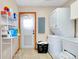 Laundry room area with washer, dryer, shelving, tile floor, and utility sink at 4939 Myakka Valley Trl, Sarasota, FL 34241