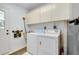 Functional laundry room with washer, dryer, utility sink, and storage cabinets for convenience at 4939 Myakka Valley Trl, Sarasota, FL 34241