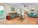 Bright living room with a plaid sofa, ceiling fan, and light wood floors at 4939 Myakka Valley Trl, Sarasota, FL 34241
