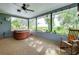 Relaxing screened porch with a hot tub, ceiling fan, and views of the expansive backyard at 4939 Myakka Valley Trl, Sarasota, FL 34241