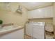 Well-equipped laundry room with a washer, dryer, sink, and ample storage cabinets at 505 S Orange Ave # 501, Sarasota, FL 34236