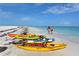 Beautiful beach view featuring white sand and clear blue water, lined with colorful kayaks at 526 67Th St, Holmes Beach, FL 34217