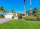 Single-story home with a white exterior, paver driveway, and tropical landscaping at 5303 Coral Blvd, Bradenton, FL 34210