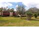 Two-story condo building with red accents, lush landscaping, and grassy area at 535 Spring Lakes Blvd, Bradenton, FL 34210