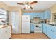 Kitchen with light blue cabinets, white appliances, and wood floors at 535 Spring Lakes Blvd, Bradenton, FL 34210