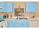 Kitchen with pass-through to dining area and light blue cabinets at 535 Spring Lakes Blvd, Bradenton, FL 34210