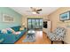 Relaxing living room with a blue sofa and sliding glass doors leading to a screened-in porch at 535 Spring Lakes Blvd, Bradenton, FL 34210