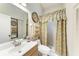 Bathroom featuring a vanity, toilet, and walk-in shower with decorative curtain at 5376 Royal Palm Ave # 5376, Sarasota, FL 34234