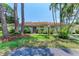 Pleasant single-story home with neatly kept lawn, mature trees and shrubbery under a clear blue sky at 5376 Royal Palm Ave # 5376, Sarasota, FL 34234