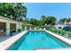 Community pool featuring clear blue water, lounge chairs, and a secure fence for resident relaxation and safety at 5376 Royal Palm Ave # 5376, Sarasota, FL 34234