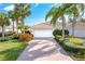 Exterior view of a house with a white garage door and lush landscaping at 5551 Avellino Pl, Sarasota, FL 34238