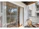 View from the balcony through the sliding glass doors to the bedroom with seating for two at 5903 Canal Dr # I24, Bradenton, FL 34207