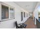 Exterior walkway of a condominium complex with seating areas, a door, and windows at 5903 Canal Dr # I24, Bradenton, FL 34207