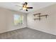 Neutral carpeted bedroom with a ceiling fan and a sun-filled window at 6706 Fairway Gardens Dr # 6706, Bradenton, FL 34203