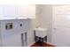 Laundry room with utility sink, cabinets, and tiled floor at 7212 Southgate Ct, Sarasota, FL 34243