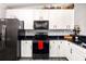 Modern kitchen with white cabinets, black countertops, and stainless steel appliances at 7315 River Hammock Dr # 206, Bradenton, FL 34212