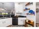 Modern kitchen with white cabinets, black countertops, and stainless steel appliances at 7315 River Hammock Dr # 206, Bradenton, FL 34212