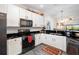 Modern kitchen with white cabinets, black countertops, and stainless steel appliances at 7315 River Hammock Dr # 206, Bradenton, FL 34212