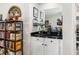 Convenient wet bar with black countertop and white cabinetry at 7315 River Hammock Dr # 206, Bradenton, FL 34212