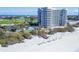 Stunning aerial view showcasing the beachfront condos, pool, and beach access at 775 Longboat Club Rd # 902, Longboat Key, FL 34228