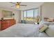 Comfortable bedroom with large windows, ceiling fan, and dresser at 775 Longboat Club Rd # 902, Longboat Key, FL 34228