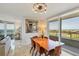 Bright dining room with lovely light fixture, wooden table, and balcony access with wonderful views at 775 Longboat Club Rd # 902, Longboat Key, FL 34228