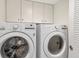 Modern laundry room with front-loading washer and dryer, ample storage cabinets, and efficient layout at 775 Longboat Club Rd # 902, Longboat Key, FL 34228