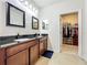 Bathroom with double vanity, walk-in closet, and large mirror at 8267 Nandina Dr, Sarasota, FL 34240