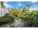Landscaped yard with lush tropical plants and a stone path at 8335 Glenrose Way # 1513, Sarasota, FL 34238